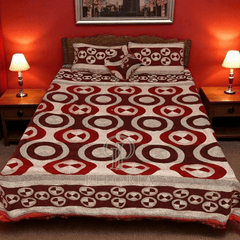 Bed with red and white patterned comforter in a bedroom setting with two lamps.