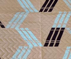 Quilt with geometric pattern on beige fabric