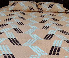 Beige bedspread with black and blue geometric pattern on a bed
